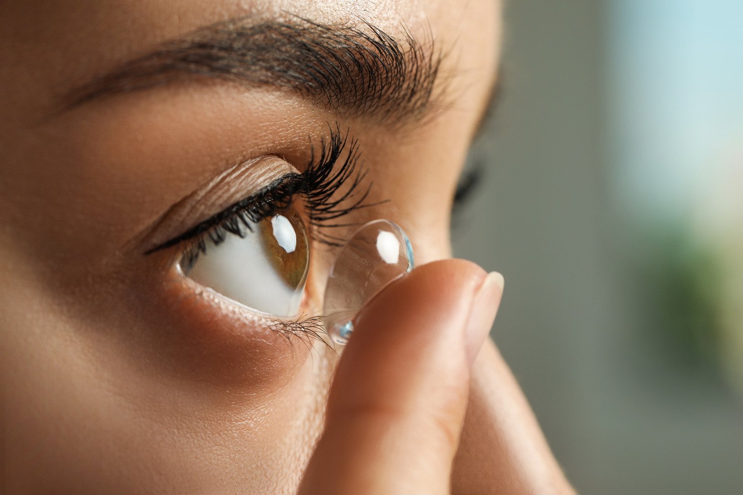 Woman puts in her contacts after a fitting and exam in Alabama